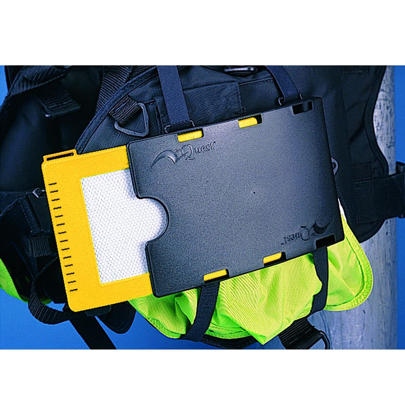 Diver wearing wetsuit and gloves holding yellow and gray underwater writing slates while diving