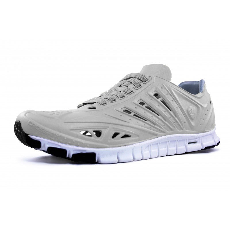Crosskix APX Greystone athletic shoe angled side view highlighting the streamlined silhouette, grey synthetic upper with geometric cutouts, and segmented white sole design