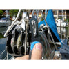 Close-up of sailor's hand holding MAC Coltellerie sailing knife on boat deck with rigging equipment visible
