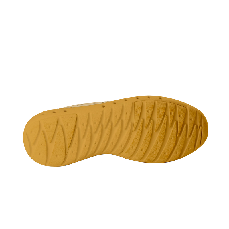 Bottom sole view of Crosskix Tetra Sand shoe displaying golden yellow textured rubber outsole with directional tread pattern