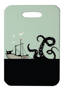 Innovate Scuba Concepts luggage tag showing a black kraken attacking a fishing boat above a black ocean, set against a light sage background.