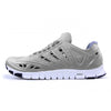 Crosskix APX Greystone athletic shoe side profile view showing grey upper with perforated design details, white sole with blue accents, and flexible outsole pattern
