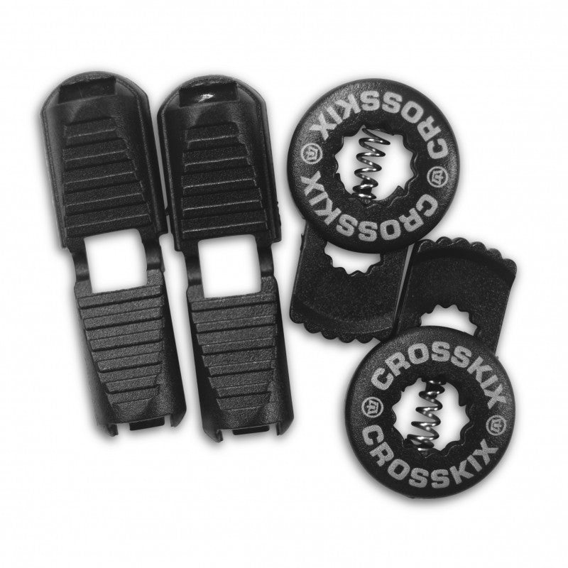 Crosskix elastic shoelace components laid out showing two black lace clips and two circular Crosskix branded end caps with logo design