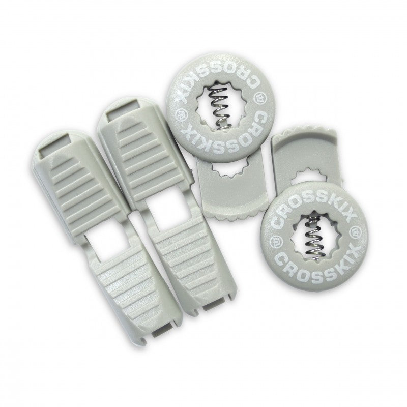 Crosskix elastic shoelace components laid out showing two grey lace clips and two circular Crosskix branded end caps with logo design