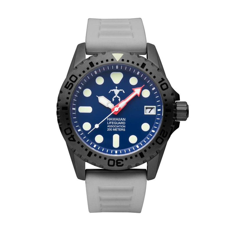 Hawaiian Lifeguard Association dive watch with black case, blue dial, luminous markers, red arrow minute hand, and white rubber strap