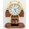 Maritime quartz clock mounted in a brass ship’s wheel on a wooden stand with rope detailing, perfect for desktop or shelf display.
