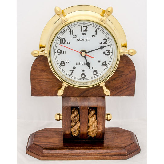 Maritime quartz clock mounted in a brass ship’s wheel on a wooden stand with rope detailing, perfect for desktop or shelf display.