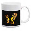 White ceramic mug with twin golden seahorses facing each other on a solid black background.